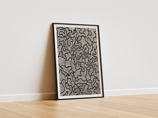 Framed abstract line artwork on a white wall with wooden floor