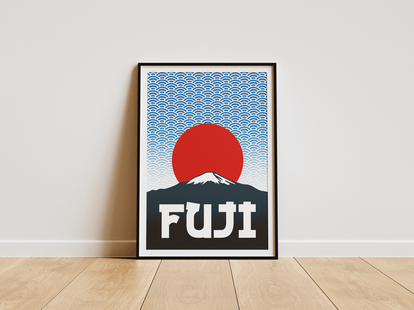 Framed artwork of Mount Fuji with a red sun and blue wave pattern on a white wall.