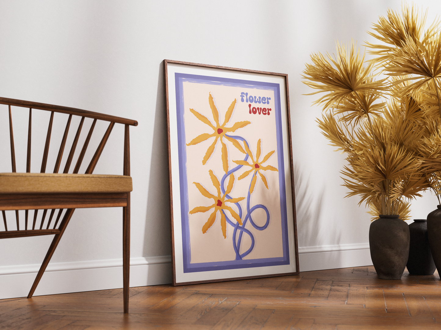 Framed artwork with floral design and text on a wall next to a wooden chair and decorative plants.