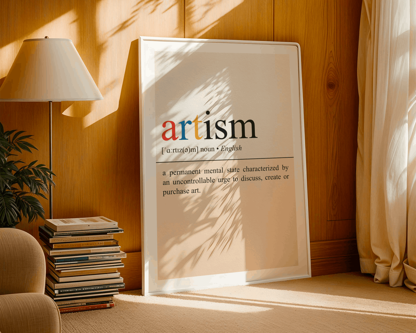 Framed poster with the word 'artism' in a home setting with a lamp and books.