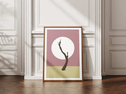 Framed artwork with a minimalist design of a Namibian tree against a white circle on a pink background, leaning against a white wall.