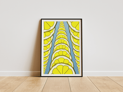 Framed abstract art print with lemon slices on a white wall.