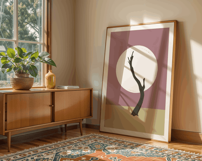 Framed artwork of a tree in Deadvlei in Namibia on a wall next to a wooden sideboard with plants