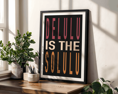 Framed poster with 'DELULU IS THE SOLULU' text on a wooden shelf with plants.