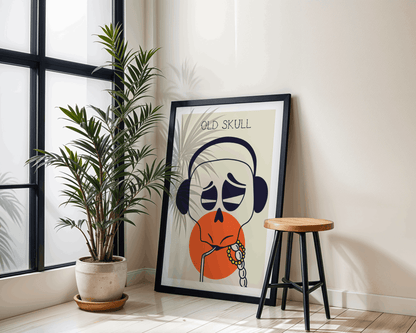 Framed artwork titled 'Old Skull' on a wall next to a plant and stool.