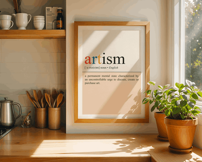 Framed art print titled 'artism' on a kitchen counter with plants and utensils.