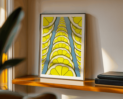 Framed abstract art with lemon slices on a wooden shelf.