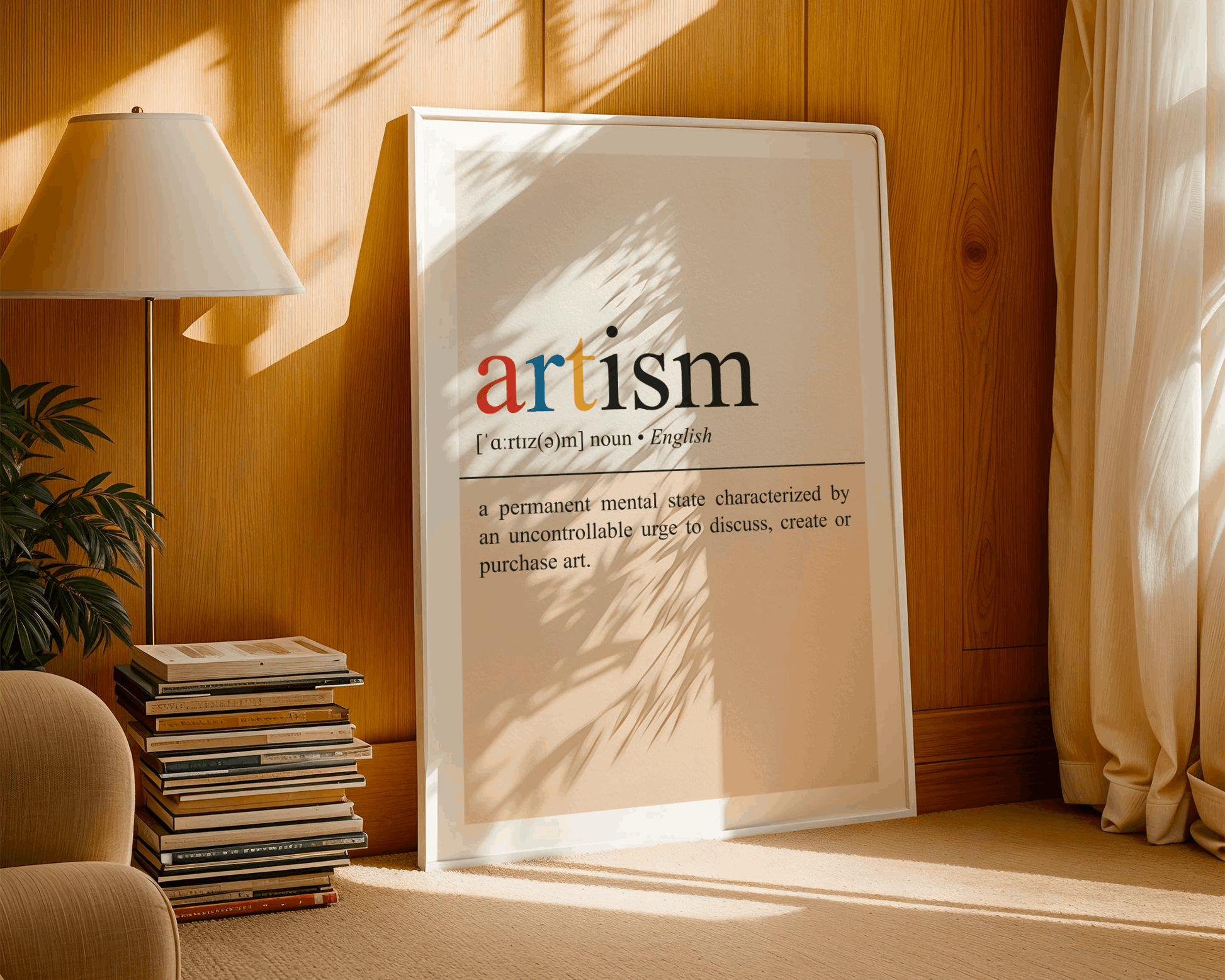 Framed poster with the word 'artism' in a home setting with a lamp and books.