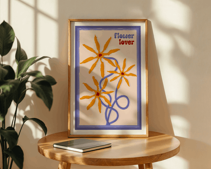 Framed artwork with floral design and 'flower lover' text on a wooden table.