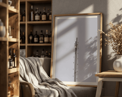 Framed ski artwork on a wall with a bookshelf and decorative items in the background.